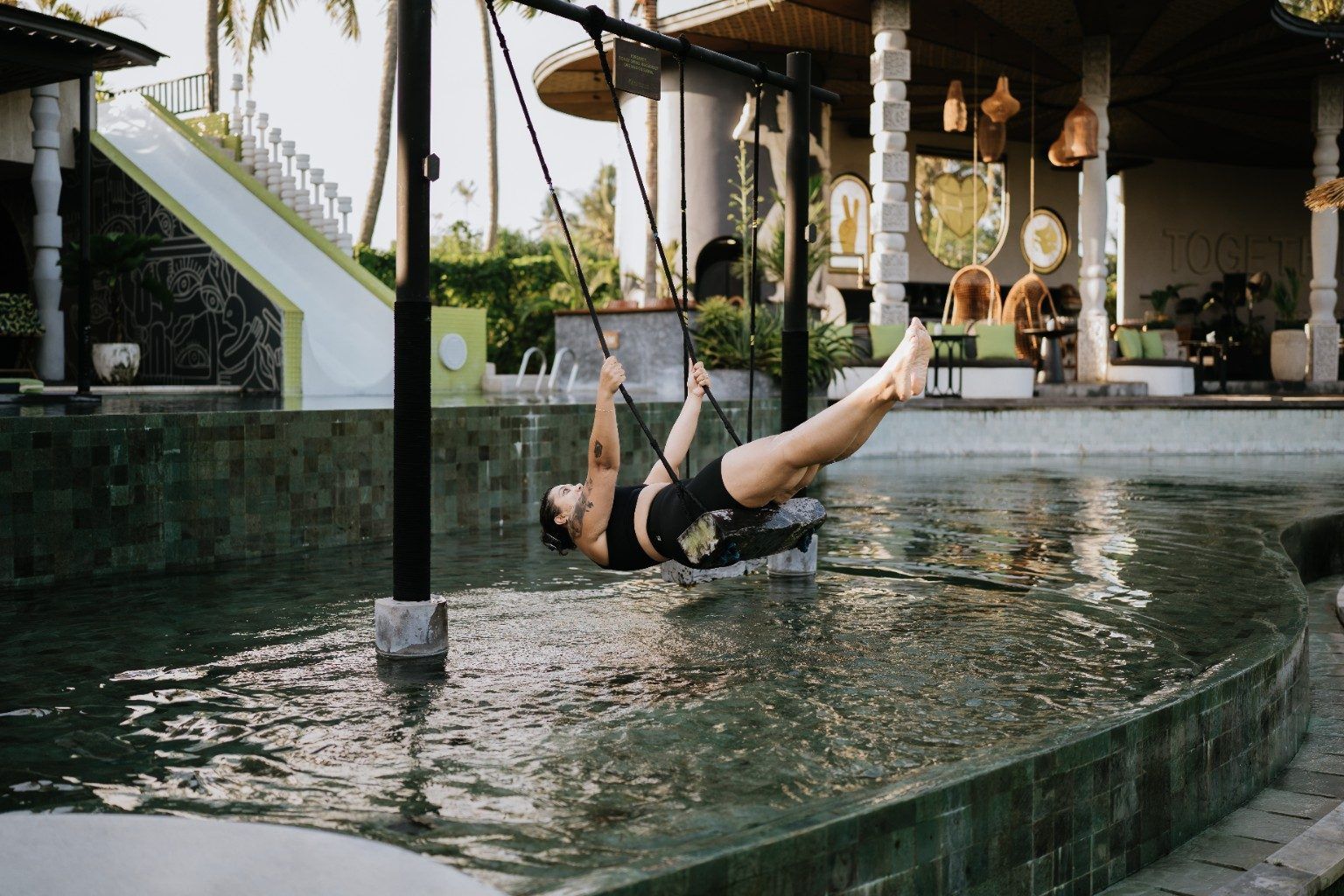 Natasha Kisten on a swing over a pool in Bali